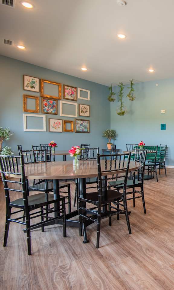 A kitchen with a dining table and chairs.