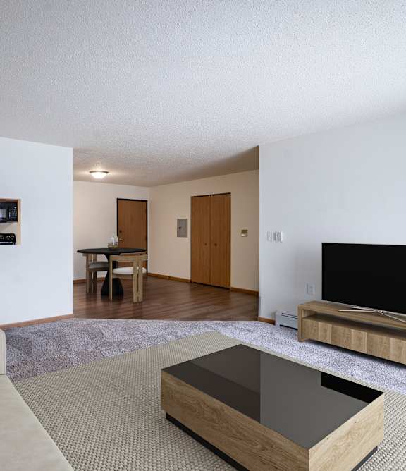 A living room with a couch, coffee table, and television. Moorhead, MN Woodstone Apartments