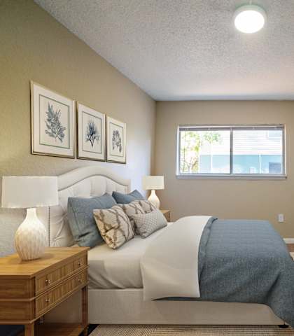 A bedroom with a bed, desk, and chair.