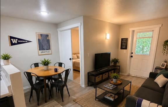 A kitchen with a sink, a table and chairs, and a plant.