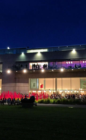 a crowd of people sitting on mats in front of a building