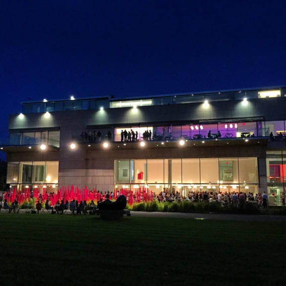 a large building with a large lawn in front of it and a large group of people standing