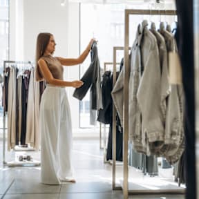 Woman Smiling while Shopping for Clothes in Store