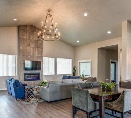 A modern living room with a fireplace and a dining table set up.