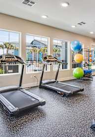 A gym with treadmills, elliptical machines, and a weight machine.