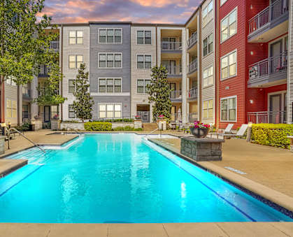 A swimming pool in front of apartment buildings.