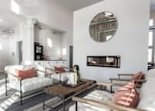 Thumbnail 2 of 8 - A living room with a fireplace and a mirror on the wall.