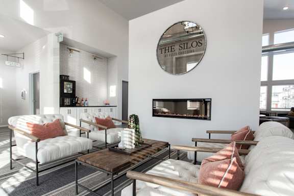 A living room with a fireplace and a mirror on the wall.