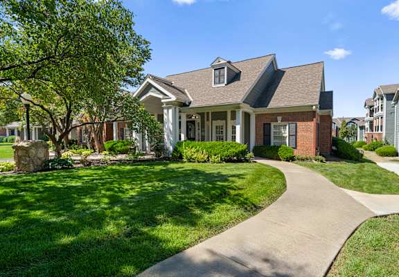 A house with a stone pillar and a tree in front of it. at Somerset Oaks Apartment Homes, Olathe