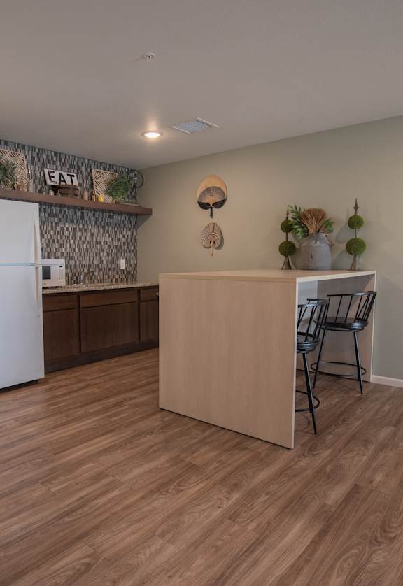 a kitchen and dining area with a refrigerator and a table and chairs
