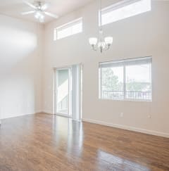an empty living room with a hard wood floor and a window