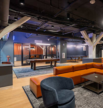 A modern office space with orange and grey furniture. at Textile Apartments, Cincinnati, OH, 21286
