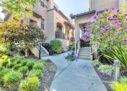 an apartment building with stairs and a sidewalk