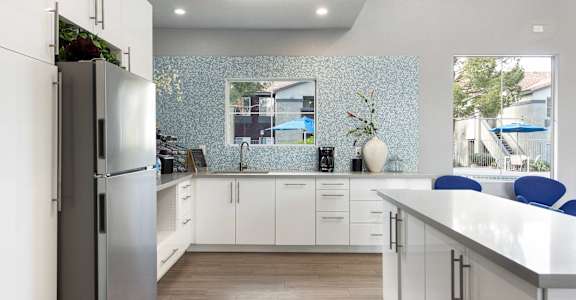 a kitchen with white cabinets and a stainless steel refrigerator
