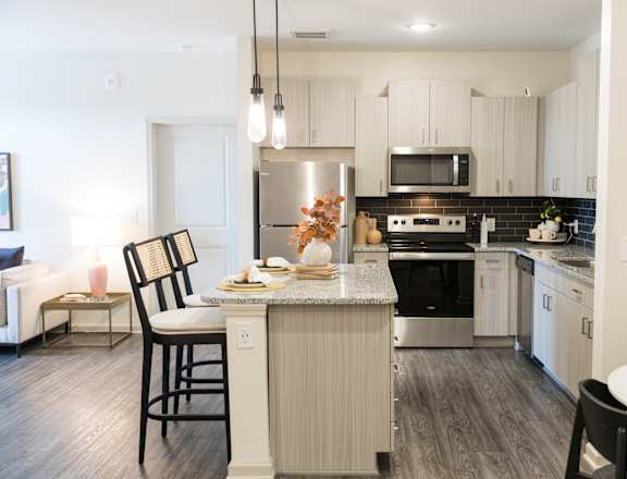 Modern kitchen with island seating and stainless appliances at The Crest at Acworth Apartments, Acworth, GA, 30102