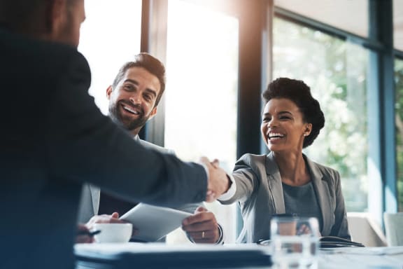 a man and a woman shaking hands at a table