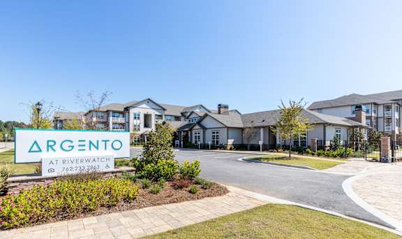 a sign that reads argento at riverwalk in front of a row of houses