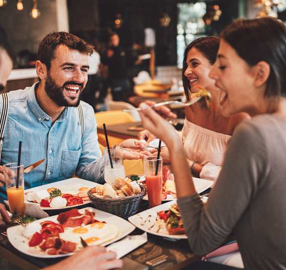 a group of people sitting at a table eating food at The Levi Luxury Apartments, McDonough, 30253