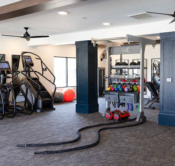 A spacious gym with a variety of equipment including treadmills, weights, and exercise machines.