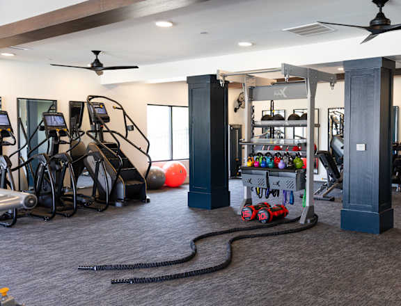 A gym with a variety of equipment including treadmills, exercise bikes, and weight racks.