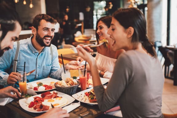 a group of people sitting at a table eating food