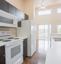 a kitchen with white appliances and black cabinets and a white refrigerator