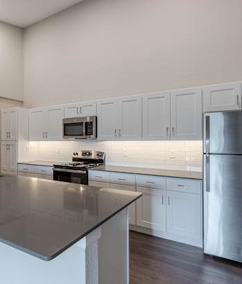 A modern kitchen with a large island and stainless steel appliances.
