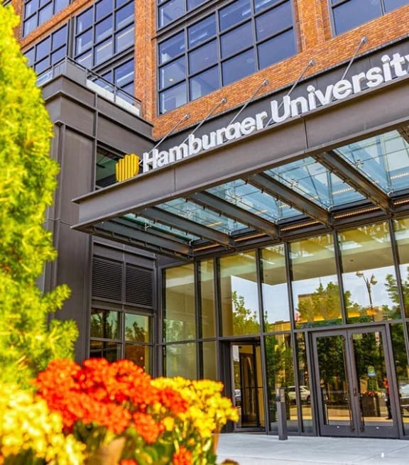 the front of a university building with flowers in front