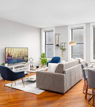 a living room with a couch and a table with chairs  at Somerset Place Apartments, Chicago, IL, 60640