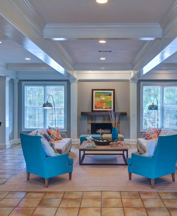 A living room with a fireplace and two chairs at Austin Chase Apartments, Macon, Georgia