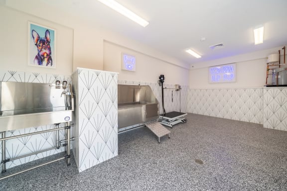 a large room with a coffee machine and a painting of a dog on the wall at The Oasis at Plymouth, Massachusetts