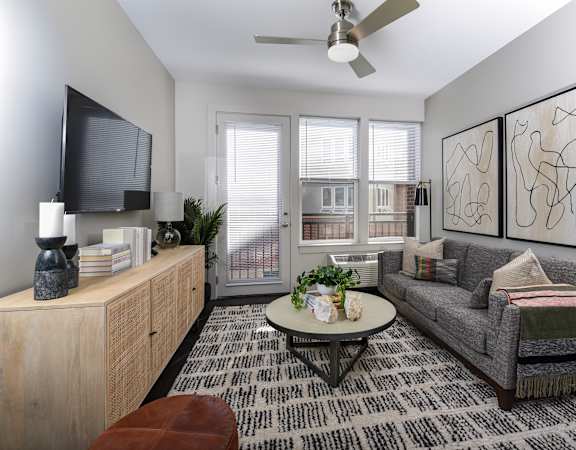 A living room with a grey couch, a coffee table, and a television.