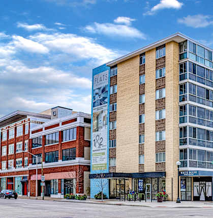 A modern multi-story building with a glass facade is the main focus of the image.