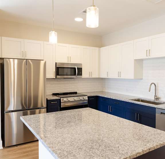 A modern kitchen with a large island and a dining area.