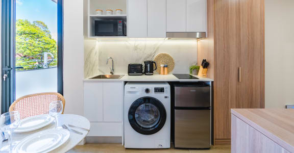 a kitchen and dining area with a washing machine and a dishwasher