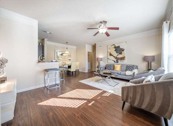A living room with a grey couch and a wooden floor.