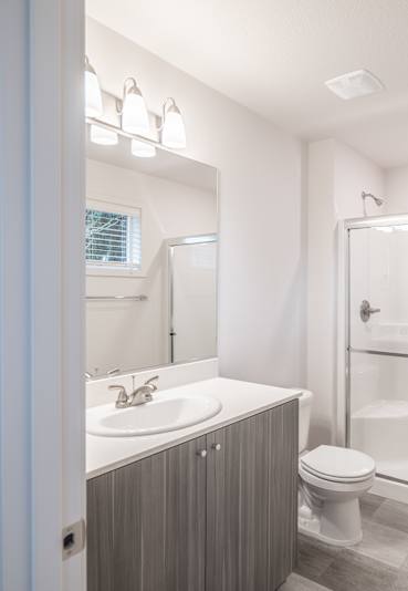 A bathroom with a toilet, sink, and shower.