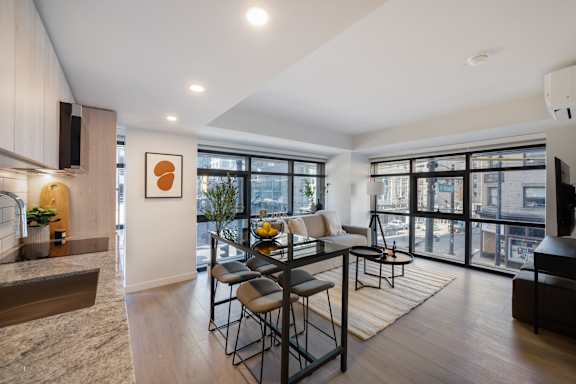 A modern living room with a dining table and chairs.