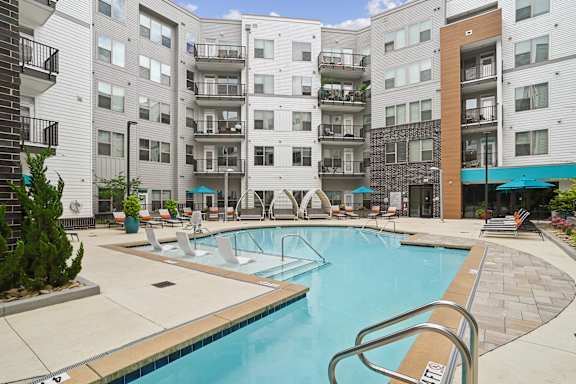 A swimming pool in front of apartment buildings.