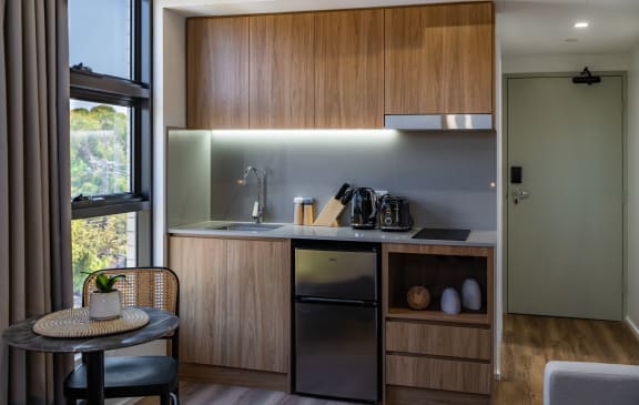 a kitchen with a small table and a sink and a window