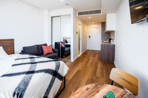 a bedroom with a bed and a desk and a living room
