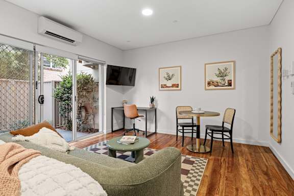 A living room with a couch, chairs, and a table.