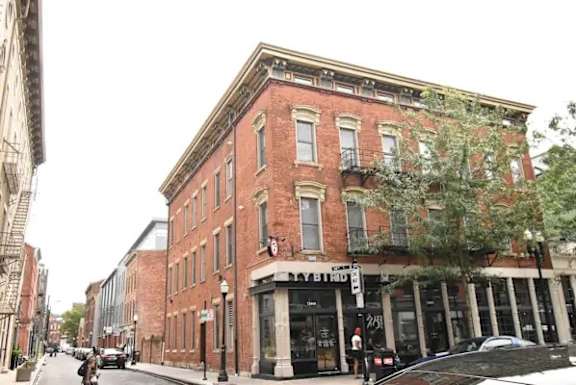 A red brick building with a black car parked in front.