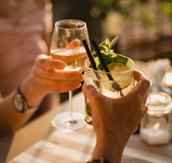 Two people toasting with drinks in their hands.at 21 West, New York, NY 10006