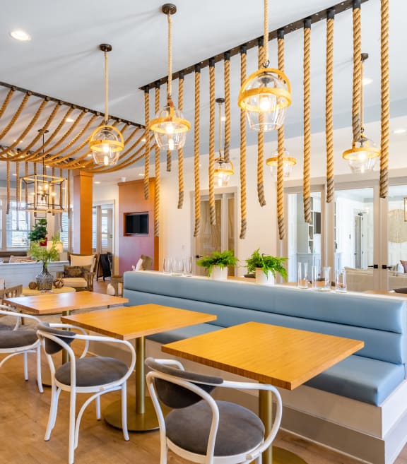 a restaurant with blue couches and wooden tables and chairs