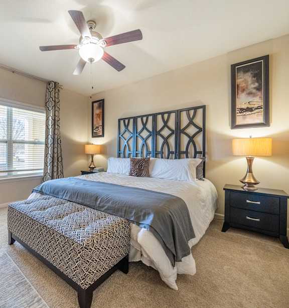 a bedroom with a bed and a ceiling fan