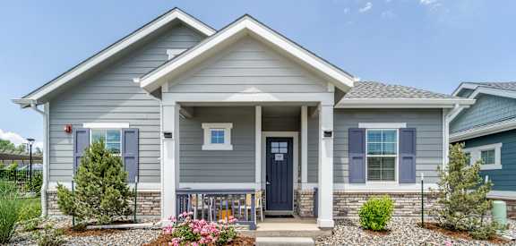 A house with a front yard and a gravel path leading to the front door.