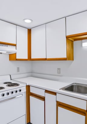 A kitchen with white appliances and wooden cabinets.