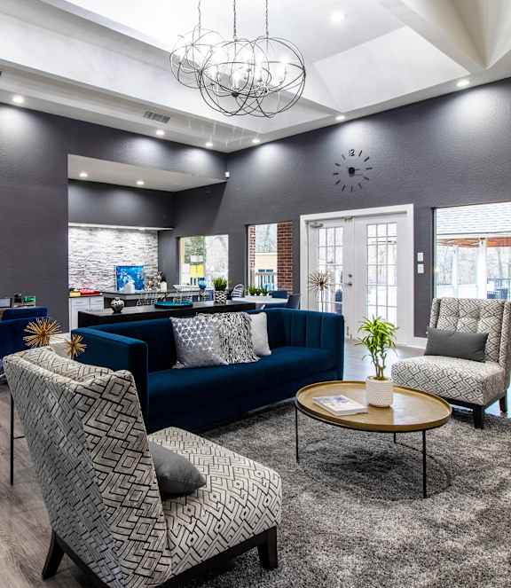 A living room with a stone fireplace and a grey sofa.
