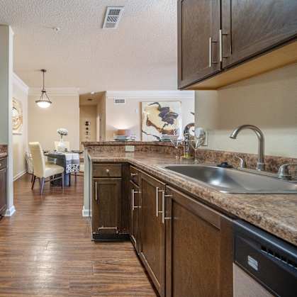 A kitchen with dark wood cabinets and a black stove top oven.